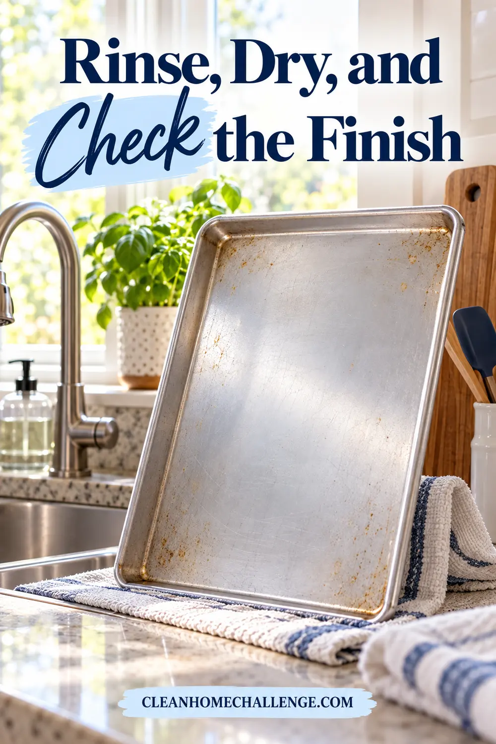 A clean but slightly discolored sheet pan dries upright beside a kitchen sink.