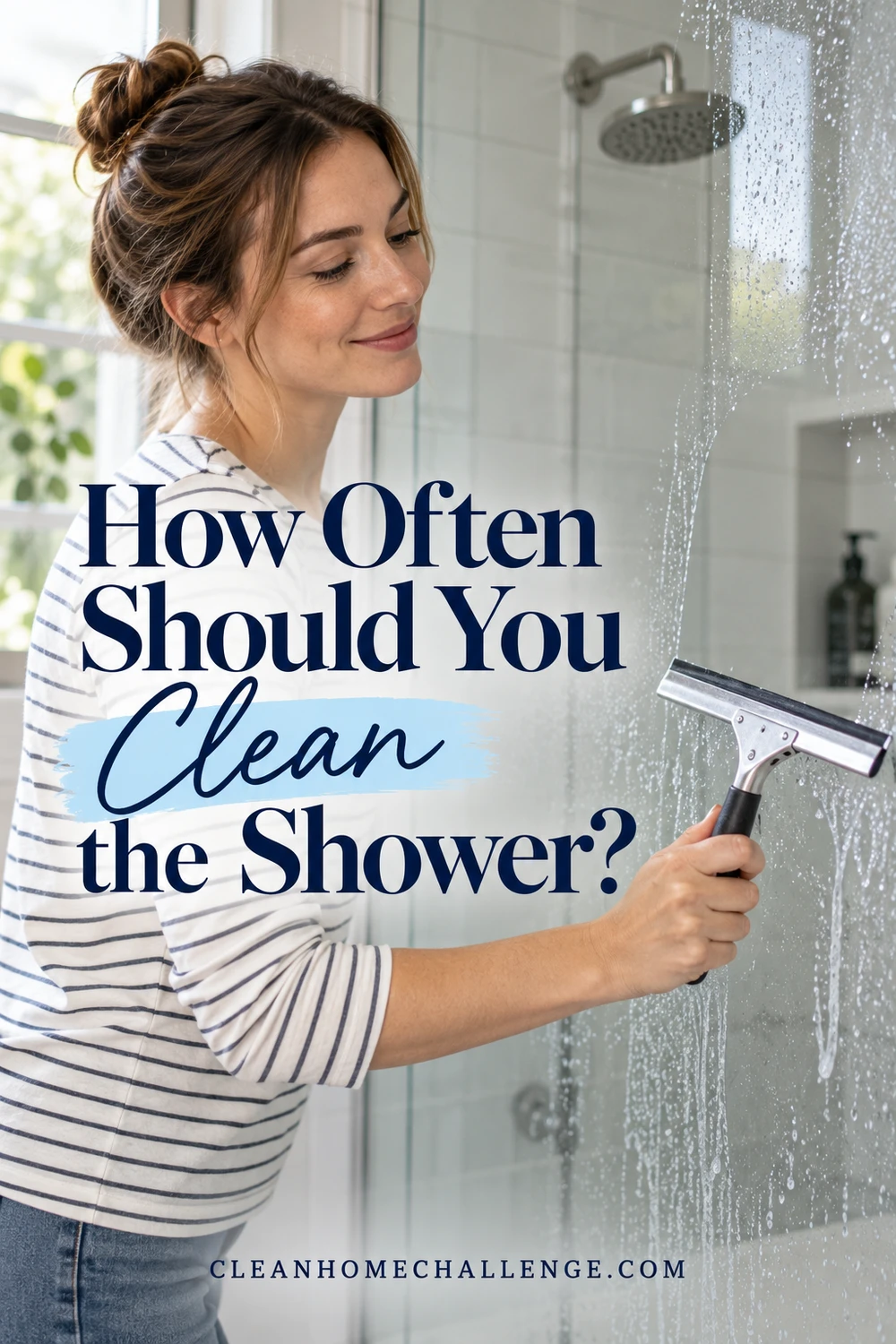 Woman in a striped shirt drawing a squeegee across a wet glass shower screen.