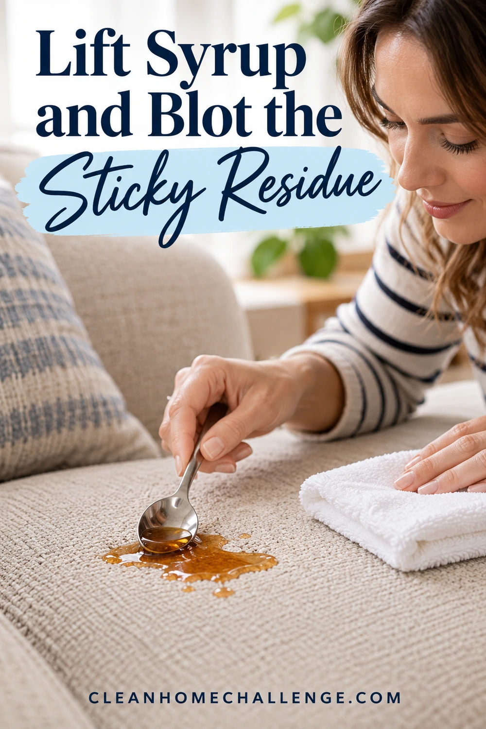 A rounded spoon lifts amber syrup from beige upholstery while a folded white towel rests nearby.