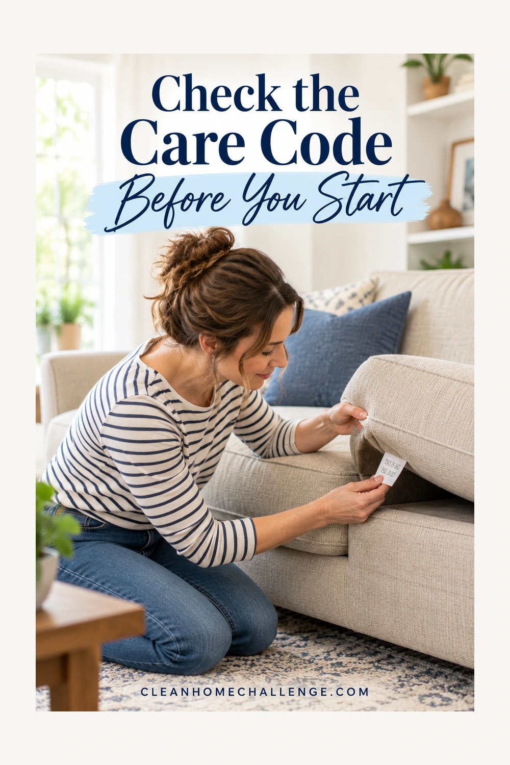 A striped-shirt woman reads a sewn-in care tag beneath a beige sofa cushion.