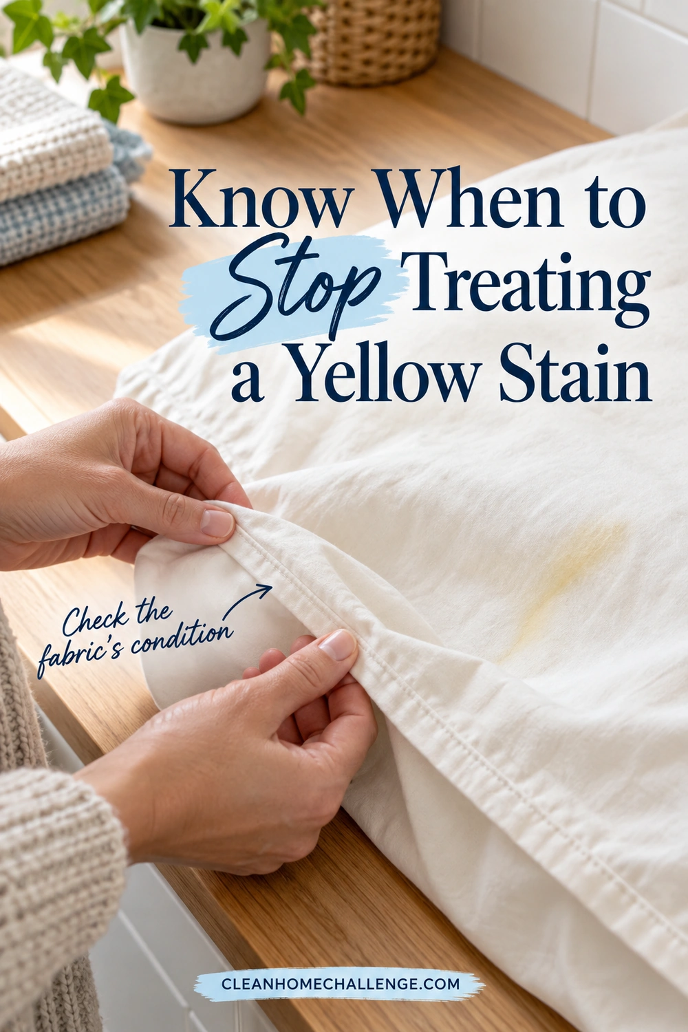 Hands inspect a pillowcase seam beside a yellowed area on a wooden laundry counter.