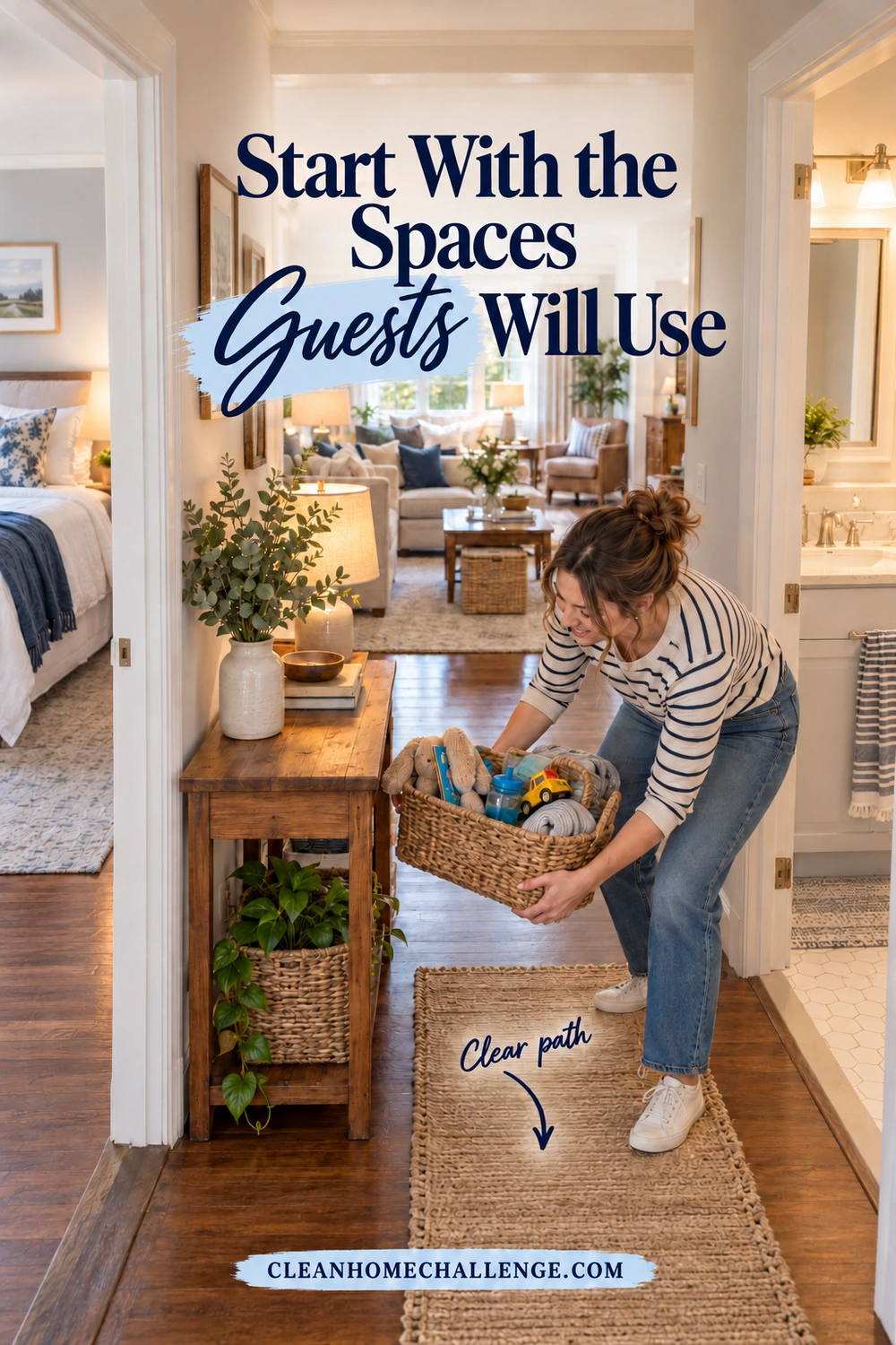 A woman collects loose items in a basket along a clear hallway, with a prepared guest bed to the left, a bathroom to the right, and a shared living room beyond.