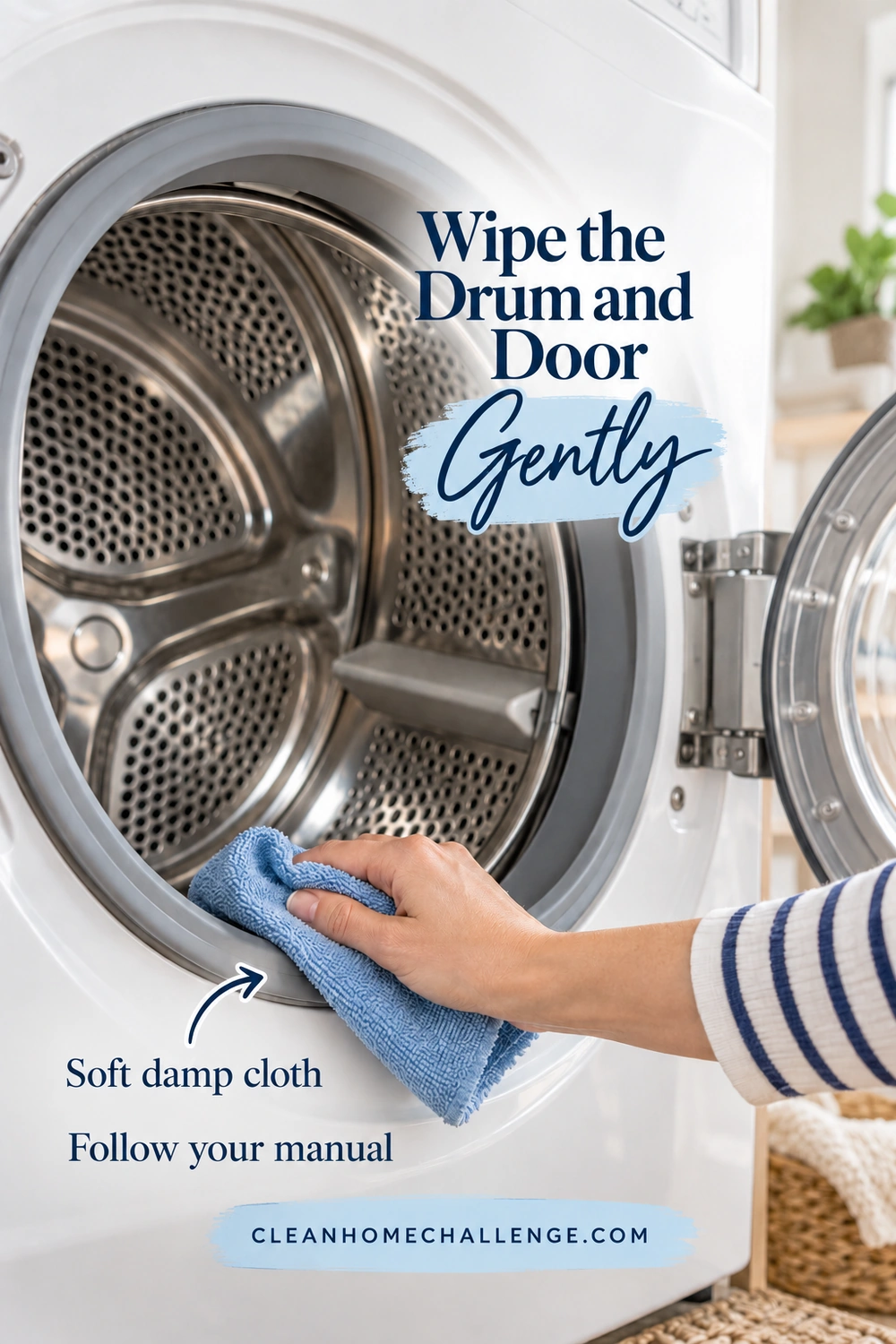 A hand in a striped sleeve wipes the front rim of an open stainless-steel dryer drum with a blue cloth.