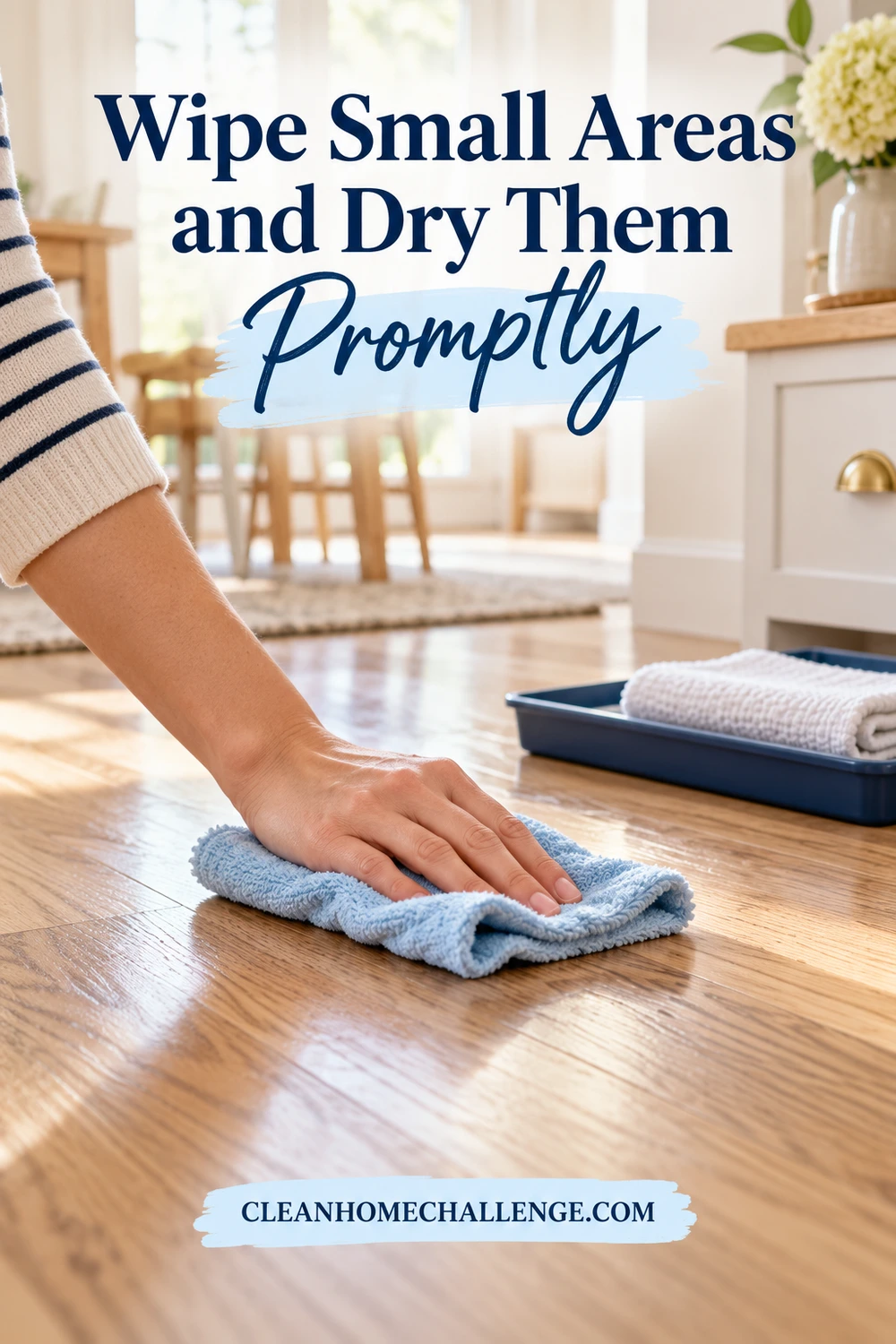 A hand moves a soft blue cloth along a clear wooden desktop with a separate dry cloth nearby.